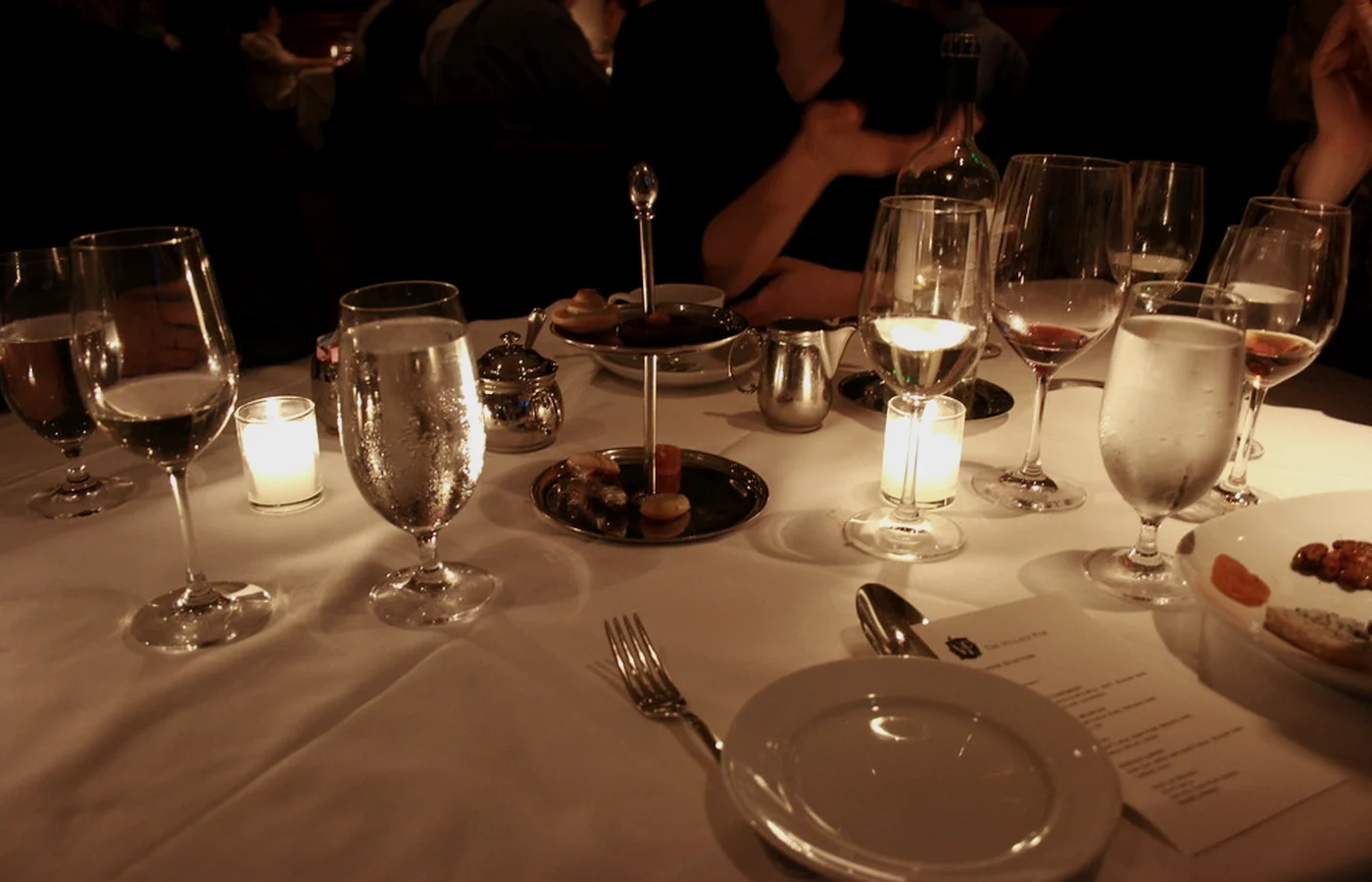 Mesa servida con copas y velas encendidas al anochecer
